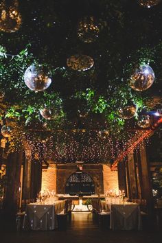 the ceiling is decorated with disco balls and greenery as well as tables set for dinner