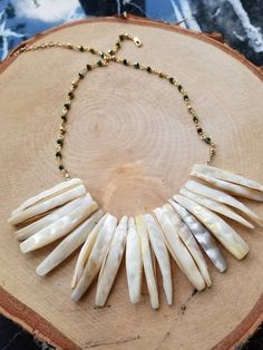 This one of a kind necklace is 16 inches with a 3 inch extender. The genuine mother of pearl sticks are 1 1/2 inches long. The chain is handmade with gold wire, faceted olive green beads, and gold filled beads. Non tarnish. Mother of Pearl can be an part of anyone's path to releasing old emotions or deepening their spiritual connection. Wearing Mother of Pearl jewelry is said to attract prosperity, heighten intuition, and stimulate the imagination. Necklace Shell, Mother Of Pearl Jewelry, Yellow Quartz, Celestial Necklace, Necklace Chunky, Mother Of Pearl Necklace, Green Beads, Mother Birthday Gifts, Feather Pendant