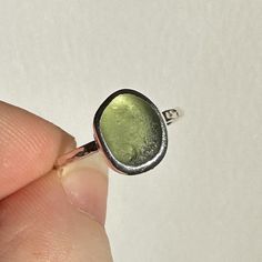 A perfect little round pale green sea glass and recycled sterling silver ring.  Size K and set on a hammered 1.5mm band. The shade of the glass depends on the lighting so I have shown some photos of it in direct sun light where it really glows as well as in normal natural light so you can get a real idea of the colour.  Handmade by myself in my Dorset studio using traditional silversmithing techniques. It will come packaged in sustainable packaging and an eco friendly Glänzen Designs box. If have any questions feel free to message me ! Hippy 70s, Silversmith Rings, Silver Pinky Ring, Silversmithing Jewelry, Silversmith Jewellery, Sea Glass Ring, Glass Ring, Sun Light, Granola Girl