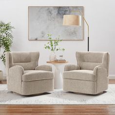 two beige chairs sitting on top of a rug next to a table with a potted plant