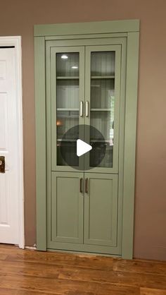 a green cabinet sitting in the corner of a room next to a white door and wooden floor