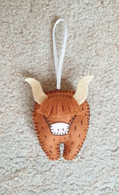 an ornament shaped like a fox with horns and ears hanging on a wall