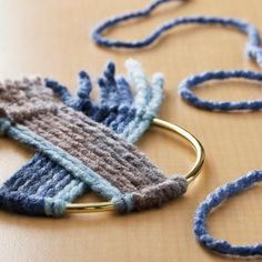 a pair of blue and grey knitted scarves on a table with gold ring