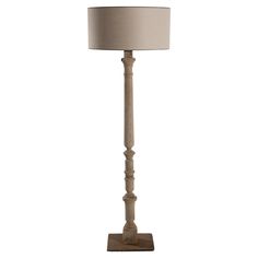 a wooden floor lamp with a beige shade