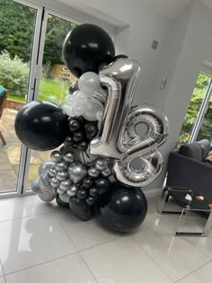 balloons are arranged in the shape of the number twenty eight, with black and silver balloons