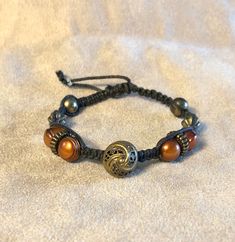 Braided bracelet with antique button. Copper and antique brass colored beads. Adjustable 7.5-9.25 inches. Clear seed beads used to pull close. Braided Bracelet, Antique Buttons, Braided Bracelets, Brass Color, Beaded Bracelet, Antique Brass, Seed Beads, Beaded Bracelets, Copper