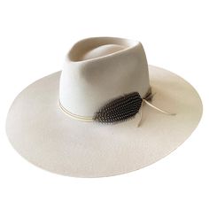 Our montana wide brim fedora in cream is a creamy off white lite stockman felt trimmed with tonal buckskin color deer tan leather and a pheasant feather. This hat is stiff and has no movement so please size accordingly. can be exchanged or returned for site credit only. Add "custom embroidery" to make it more personal. Made in the USA. brim length 4 inch. crown height 4 inch crown width 5 inch small 21-22 inch circ medium 22-23 inch circ large 23-24 inch circ Luxury Fur Felt Fedora With High Crown, Luxury Adjustable Cream Fedora, Western Wedding Hat With Feather, Luxury White Hat Bands For Ranch, Western Style Panama Hat With Flat Crown For Fall, Elegant Ranch Fur Felt Fedora, Elegant Fur Felt Fedora For Ranch, Elegant Ranch Style Fur Felt Fedora, Adjustable Beige Fur Felt Fedora