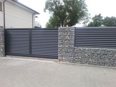 a fence made out of stone blocks next to a house