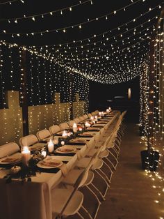 a long table is set up with candles and place settings for the dinner guests to enjoy