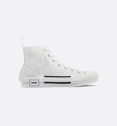 The B23 high-top sneaker is set apart by its layering of transparent paneling and white Dior Oblique canvas. Essential details, such as eyelets and a lace-up front, a white rubber sole, a rounded and reinforced toe as well as a rear tab recall the codes of the classic high-top style. The sneaker is further enhanced with contrasting details on the sides, including a Dior signature, and pairs easily with any casual outfit.. Givenchy Jacket, Louboutin Bags, Off White Jacket, Versace T Shirt, Dior Sneakers, Dior Oblique, Set Apart, Hype Shoes, Newest Jordans