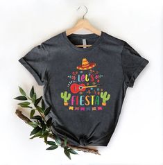 Lets Fiesta Shirt, Mexican Party Shirt, Womens Cinco De Maya Gift, Mexico Fiesta Themed Bachelorette Shirts, Hispanic Drinking Party Shirts HOW TO ORDER 1-) Please, check and review all the photos. 2-) Choose your t-shirt size and color. *Different styles of shirts may have different shades of the same color choice due to different manufacturer brands. *For this reason, we recommend matching shirts from the same styles if you want precisely matching colors (ex. Unisex, V-necks, Toddler, etc.). 3 Multicolor Crew Neck Shirt For Cinco De Mayo, Multicolor Letter Print Tops For Cinco De Mayo, Funny Print Short Sleeve Shirt For Cinco De Mayo, Fun Cotton Tops For Cinco De Mayo, Casual Multicolor Shirt For Cinco De Mayo, Fiesta Graphic Print Short Sleeve Tops, Short Sleeve Graphic Print Tops For Fiesta, Short Sleeve Tops With Graphic Print For Fiesta, Casual Multicolor T-shirt For Fiesta