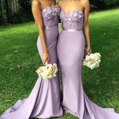 two women in purple dresses standing next to each other