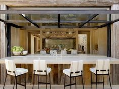 an open kitchen and dining area with white chairs