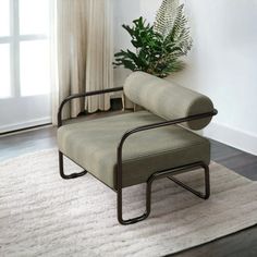 a living room with a chair and potted plant on the floor next to a window