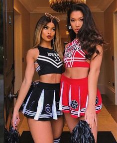 two beautiful young women standing next to each other in cheerleader outfits and holding bags