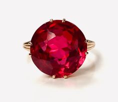 an oval shaped red stone ring with gold accents