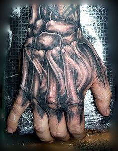 a man's hand with tattoos on it