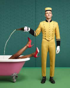 a man in yellow uniform standing next to a bathtub with high heels on it