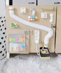 a wooden cabinet with various items attached to the wall and on top of it is a phone charger