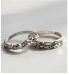 two silver wedding rings sitting next to each other on top of a white countertop