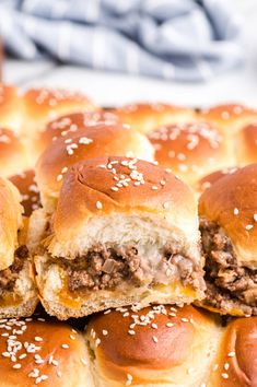 several hamburger sliders stacked on top of each other with sesame seed sprinkles