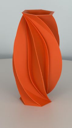 an orange vase sitting on top of a table