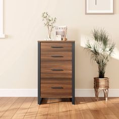 a wooden dresser sitting next to a potted plant on top of a hard wood floor