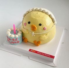 a cake shaped like a duck with a birthday candle on it's side and a small cake in the shape of a bird