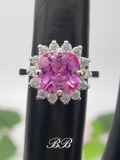 Made to order. Please allow up to 3 weeks for the production of your ring. This listing is for a 925 non-plated sterling silver or non-plated gold halo ring with a lab created pink sapphire center stone. Center Stone Gemstone Type: Lab Created Sapphire Shape: Cushion Cut Size: 8mm Weight: 2 Carat Approximately Color: Pink Quality: AAA Hardness: 9 Mohs Accent Stones Gemstone Type: Lab Created Cubic Zirconia Diamonds Shape: Round Cut Size: (14) 2mm Color: White Colorless Quality: 6A Hardness: 8.25 Mohs Available Metals (All metals are solid and non-plated) 925 Non-Plated Sterling Silver 10KT White Gold (non-rhodium plated) 10KT Yellow Gold 14KT White Gold (non-rhodium plated) 14KT Yellow Gold 14KT Rose Gold Did you know lab-created sapphires are equivalent to natural sapphires? Lab grown sap Formal Pink Sapphire Rings With Cushion Cut, Formal Pink Sapphire Cushion Cut Rings, Luxury Pink Sapphire Silver Ring, Luxury Silver Cluster Ring With Cushion Cut, Formal 14k White Gold Pink Rings, Formal Pink 14k White Gold Rings, Pink 14k White Gold Jewelry With Center Stone, Pink Sapphire Jewelry With Halo Design, Luxury Rose Gold Jewelry With Center Stone