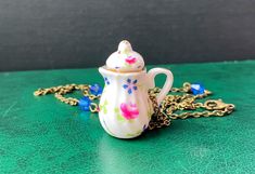 This is a fun necklace with a porcelain teapot / coffee pot pendant adorned with vintage style flowers and leaves. The chain is made of antiqued bronze and there are small blue glass beads dotted on the chain. There are two length options for the chain; medium 60cm/24" or long 80cm/31.5". Custom length is also an option, simply leave a message with your order. The necklace is cadmium, lead and nickel free. A lovely necklace, handcrafted in Finland by Selma Dreams. If you have any questions, feel free to contact me. The necklace will be sent in a little gift bag. Flower Teapot, Teapot Necklace, Ideas Birthday Gift, Porcelain Necklace, Gift Ideas Birthday, Whimsical Jewelry, Porcelain Teapot, Ideas Birthday, Lovely Necklace