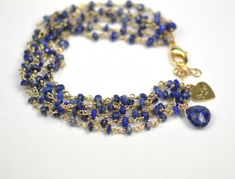 Six strands of lapis lazuli. 18kt gold plate over sterling silver. 6 3/4 inch fit length with 1 inch extender chain. Gold Bracelets With Lapis Lazuli And Natural Stones, Gold Lapis Lazuli Bracelet With Gemstone, Gold Lapis Lazuli Gemstone Bracelet, Gold Lapis Lazuli Spiritual Bracelets, Gold Lapis Lazuli Bracelets For Gift, Lapis Lazuli Bracelet, Smoky Topaz, Stone Wrapping, Star Charms