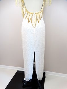 "This is a stunning gown heavily embellished with glass beading and sequins. This one is incredibly amazing! It's in perfect condition! Measurements: * Bust - 34\" * Waist - 27\" * Hips - 38\" * Length - 55\" * Tag Size - Small (please refer to measurements) All of my items come from a smoke-free and pet-free home. If you would like more information or have any questions, please don't hesitate to ask!" White Fitted Sequin Dress For Wedding, White Fitted Sequin Wedding Dress, White Embellished Evening Dress For Reception, White Sequined Floor-length Gown, Embellished Floor-length Sequin Wedding Dress, White Embellished Sequin Dress For Wedding, Floor-length Embellished Sequin Fabric For Weddings, White Beaded Fitted Evening Dress, White Fitted Beaded Evening Dress