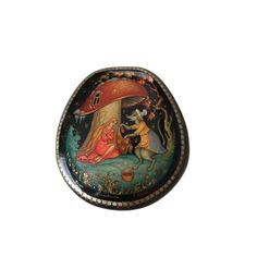 a small oval box with an image of a woman and cat in the forest on it