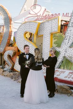 Dive into this unique wedding idea set at a neon museum! 🌟The couple stands before a charming "Stardust" sign, adding a touch of nostalgia. The groom rocks a classic black tux, while the bride stuns in a custom black jacket and tulle skirt combo. Their vows exchanged under a warm glow make it even more magical. 💍✨ #NeonMuseumWedding #UniqueWeddingIdeas #VintageWedding #WeddingInspiration #EclecticCharm Neon Museum Wedding, Neon Museum Las Vegas, Neon Museum, Caesars Palace, Downtown Las Vegas, Las Vegas Wedding, Black Tux, Museum Wedding, Las Vegas Weddings