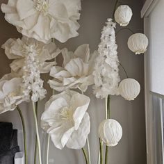 white paper flowers in vases on window sill