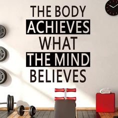 there is a gym wall with the words body achieves what the mind belies