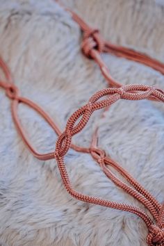 an orange rope is on top of a white furry surface