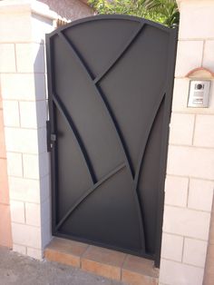 a black door with an artistic design on it's side entrance to a house