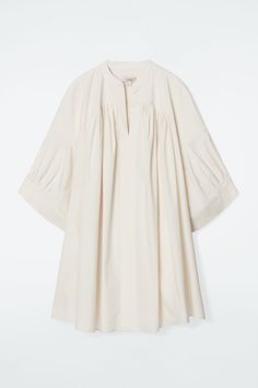 This modern tunic feels at home on long summer days, with its relaxed shape and lightweight cotton-blend fabric. It's designed with a subtle V-neck, wide cuffs and irregular pleats that lend volume. Style it as a mini dress or layer over pants for an effortless look. Relaxed fitSide-seam pockets Shell: 65% Cotton, 30% Polyamide, 5% Elastane. Excluding trims / Machine wash Back length of size 6 is 35.74" / Model wears a size 6 Spring Dresses With Pleated Sleeves, Pleated Relaxed Fit Dress For Spring, Spring Cotton Pleated Dress, Summer Workwear Tunic, Long Sleeve Pleated Hem Dress For Summer, Summer Workwear Tunic With Relaxed Fit, Summer Workwear Tunic In Relaxed Fit, Oversized Spring Tunic For Daywear, Oversized Tunic For Spring Daywear