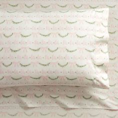 two pillow cases with pink and green feathers on them