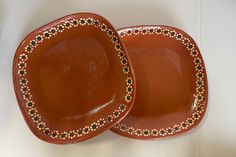 two brown plates sitting side by side on a table