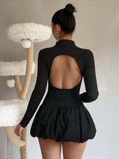 the back of a woman's body wearing a short black dress