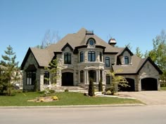 a large house with two car garages on the front and one story above it