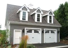 a two car garage with three windows on the top floor and one above the door