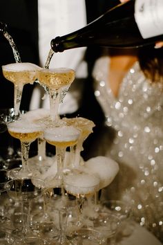 champagne being poured into wine glasses on a table