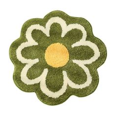 a green and white rug with a flower on the center, in front of a white background