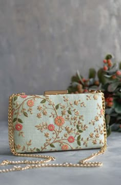 Our Floral creeper clutches are super-hot, year-round! The traditional silhouette with exquisite floral embroidery and the metal chain sling are perfect to add that oomph to your overall look and make a strong style statement, no matter what the occasion. Embroidered front and back. Dimensions (LxB): 8"x4.5" (20 cm x 11 cm) Handle length: 47" (120 cm) Handle drop: 23" (58 cm) Material: Embroidered poly silk, poly satin lining, gold metal clutch frame, gold metal sling. Features: metal lock closu Bridal Boxes, Floral Handbags, Embroidered Clutch, Silk Bag, Floral Purse, Potli Bags, Fancy Bags, Box Clutch, Trending Handbag