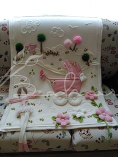 a baby carriage cake sitting on top of a white couch next to a pink flowered pillow