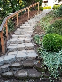 a set of stone steps leading up to the top of a hill with lights on them