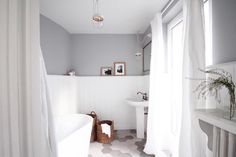 a bath room with a tub a sink and a window